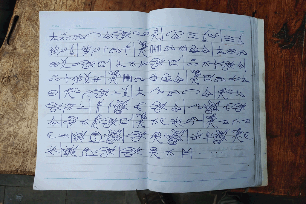 Transcriçom de umha cançom naxi no sistema de escrita dongba, tirada do quaderno de umha estudante naxi, em julho de 2018.