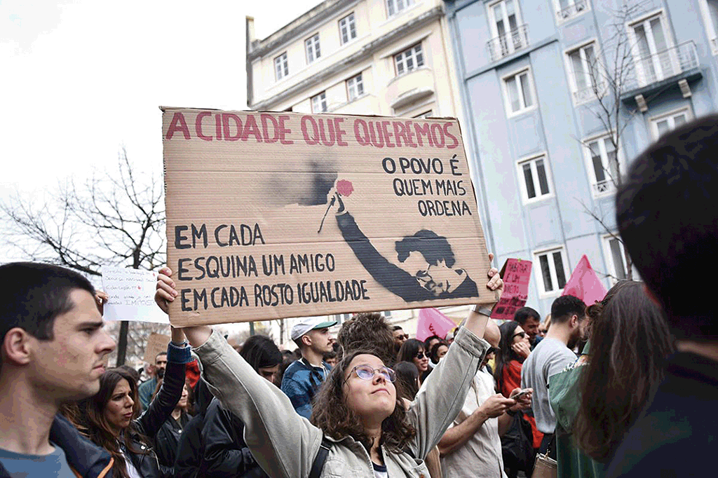Manifestaçom ‘Casas para viver’, em Lisboa. Umha moça porta um cartaz com umha imagem de Zeca Afonso com versos do 'Grândola, vila morena'. 